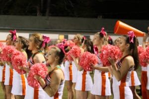 Varsity Cheerleaders cheer on the football players